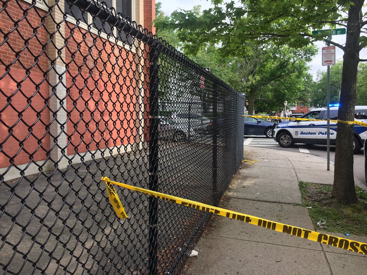 Police are back on the scene of last night's deadly double shooting. An officer is examining a bullet hole in a car and a shell casing found by the school. 