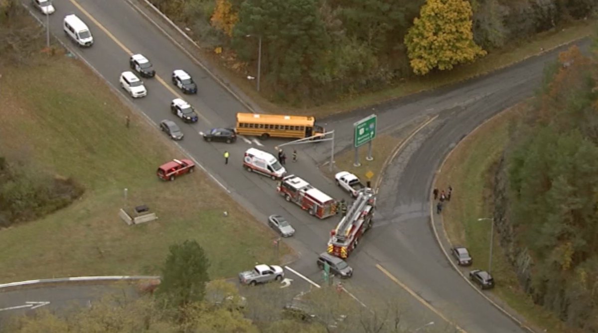 Crash involving a school bus and a car in Danvers.   Many of the students who were on the bus are   standing on side of road.  