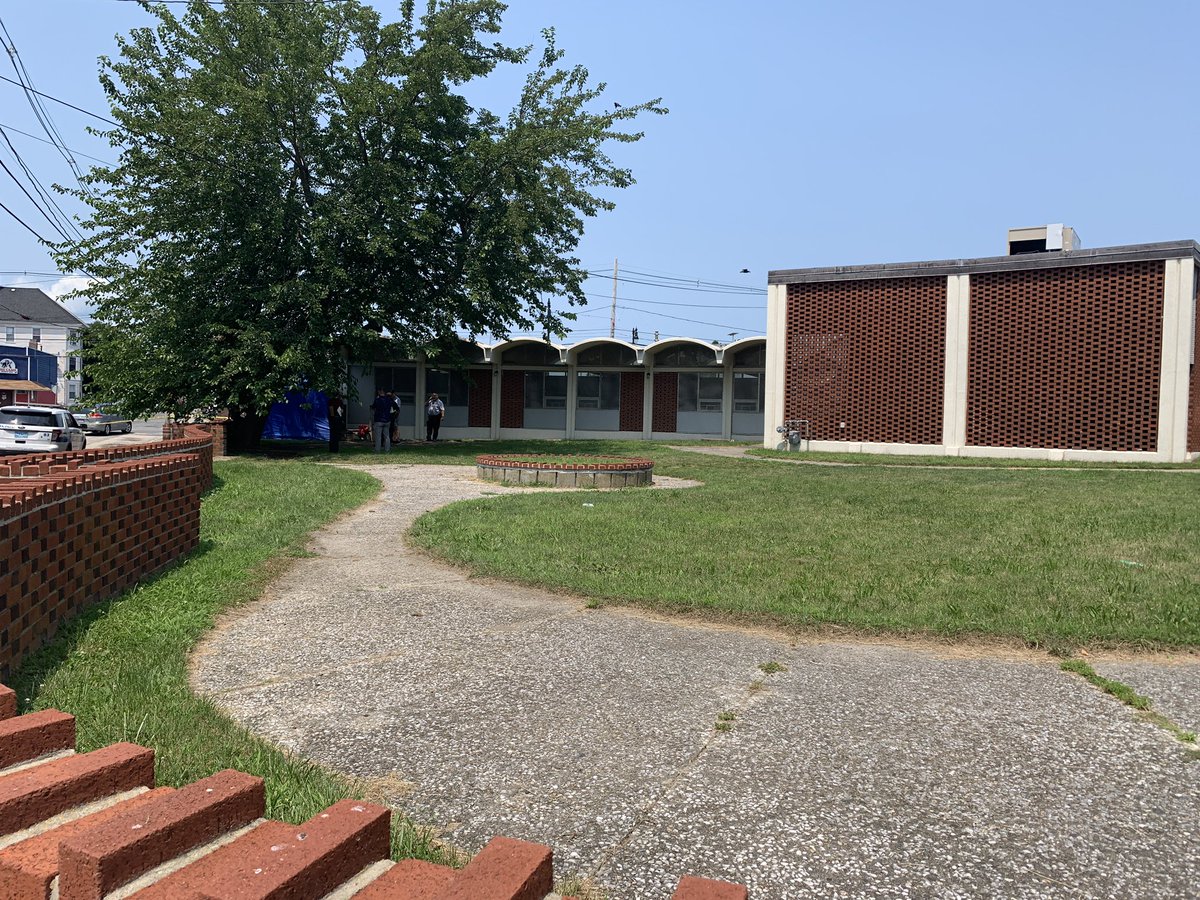 New Bedford Police have blocked off the back side of the Howland Green Library, not releasing any details yet  but we can see the investigation is centered around a blue tent.  There is a backpack and a purse on the ground near it