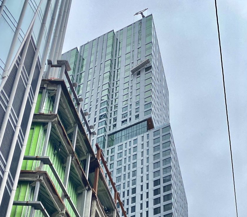 A window washing crew is dangling from the side of a Boston skyscraper.  They're on the 42nd floor of the Sudbury apartment building near City Hall. Emergency crews are on scene