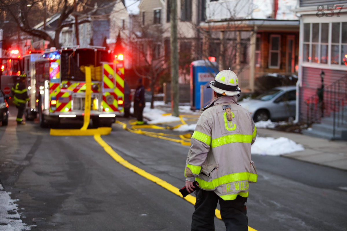 Cambridge Firefighters stretch a precautionary line at a reported structure fire on Saville St in West Cambridge. A small fire on the rear porch was quickly extinguished with a can and crews found no extension