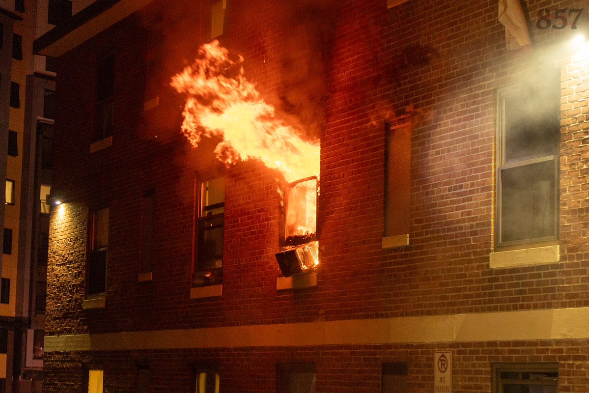 A resident jumps into the waiting arms of a Somerville Fire district chief from the 3rd floor of a burning apartment building on Powder House Blvd, late Sunday night. Firefighters rescued two additional victims from the two alarm blaze, who were all transported by Cataldo EMS