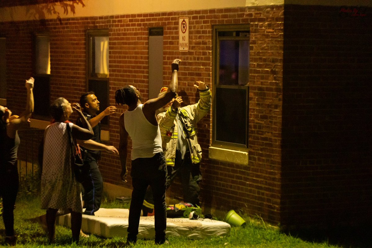 A resident jumps into the waiting arms of a Somerville Fire district chief from the 3rd floor of a burning apartment building on Powder House Blvd, late Sunday night. Firefighters rescued two additional victims from the two alarm blaze, who were all transported by Cataldo EMS