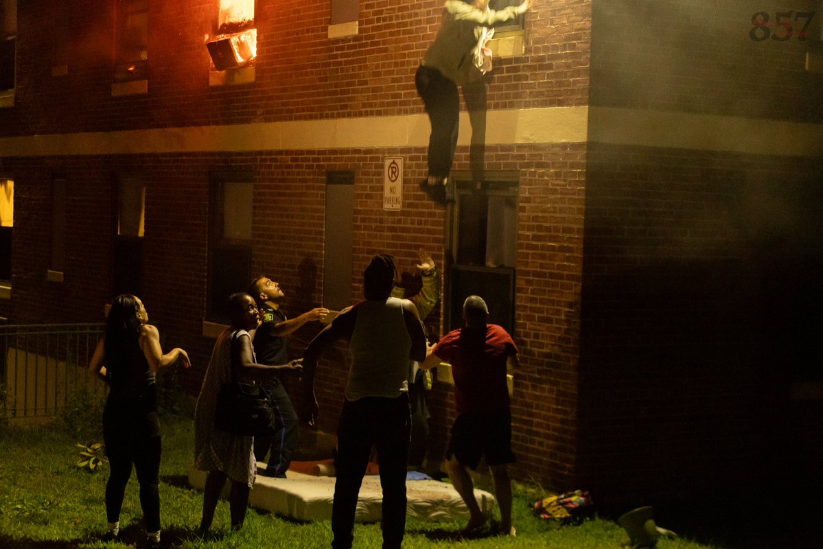 A resident jumps into the waiting arms of a Somerville Fire district chief from the 3rd floor of a burning apartment building on Powder House Blvd, late Sunday night. Firefighters rescued two additional victims from the two alarm blaze, who were all transported by Cataldo EMS