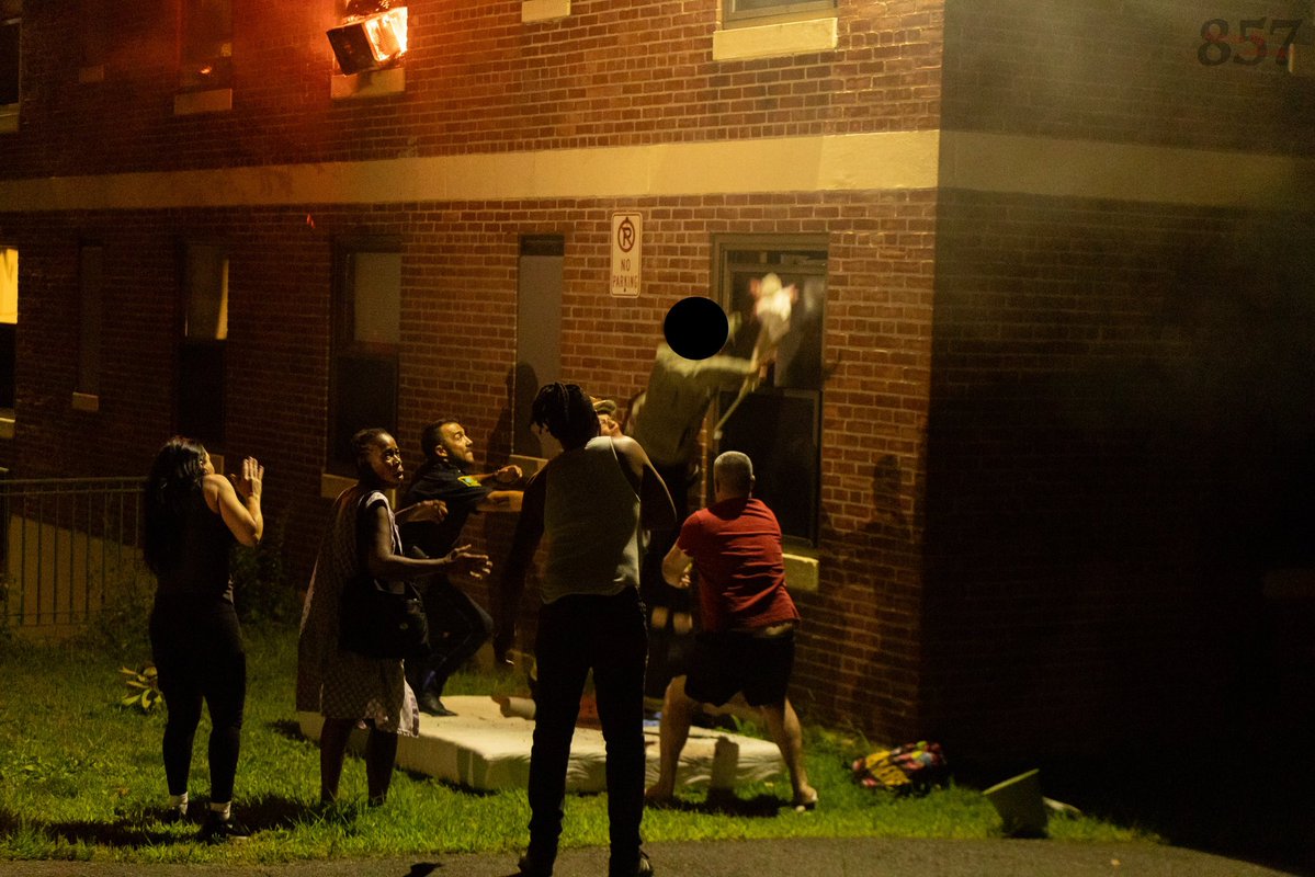 A resident jumps into the waiting arms of a Somerville Fire district chief from the 3rd floor of a burning apartment building on Powder House Blvd, late Sunday night. Firefighters rescued two additional victims from the two alarm blaze, who were all transported by Cataldo EMS