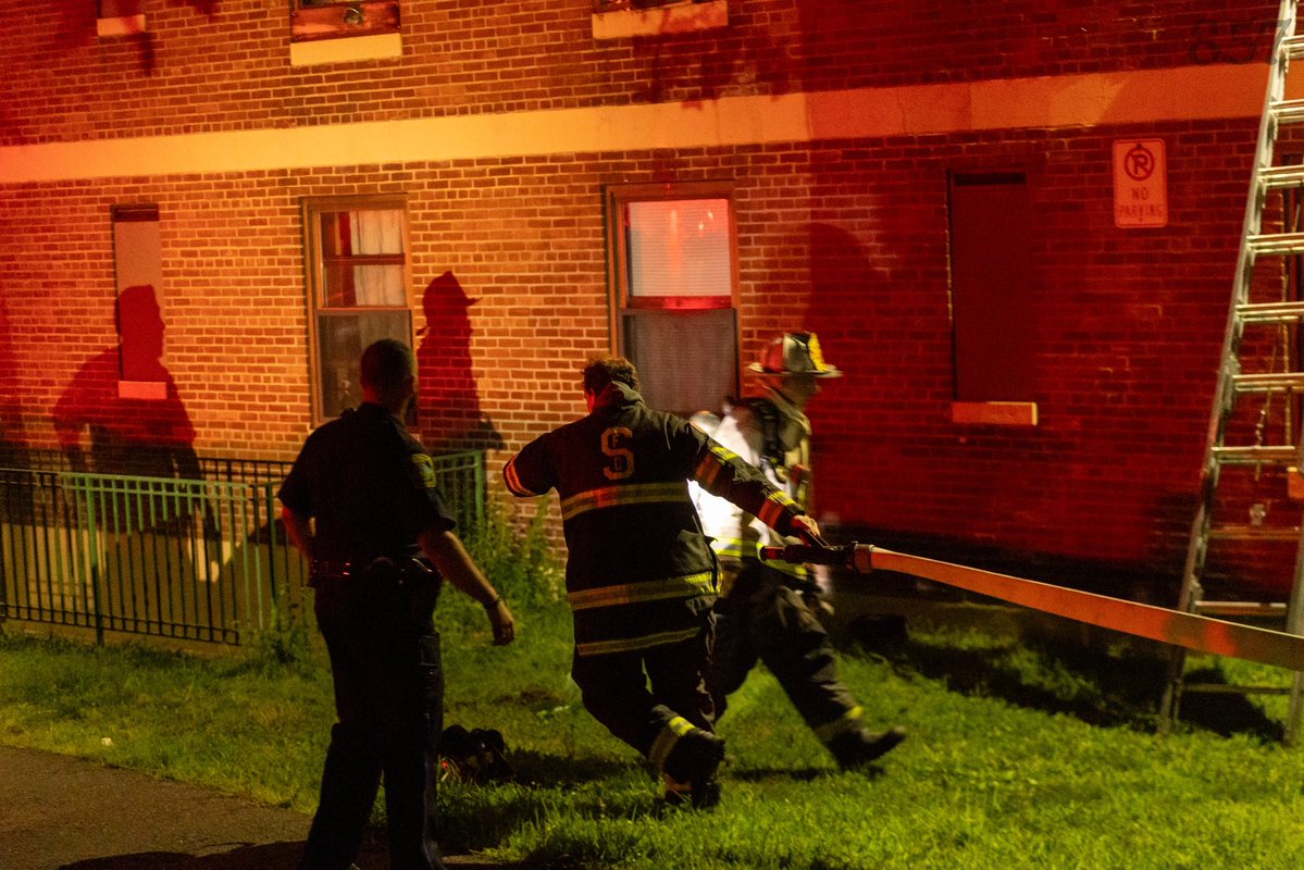 Somerville Firefighters work to battle a 2 alarm fire that consumed a second floor apartment in a 3 story public housing building on Powder House Blvd, late Sunday night