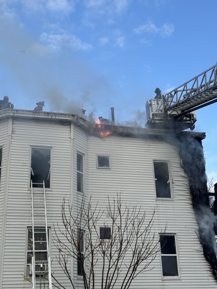 Firefighters continue to chase the fire in the eaves and roof at the 2 alarm fire on Washington st Roslindale.This is a 3 family home